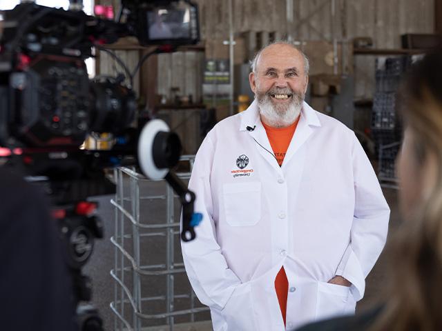 film crew filiming researcher in lab coat